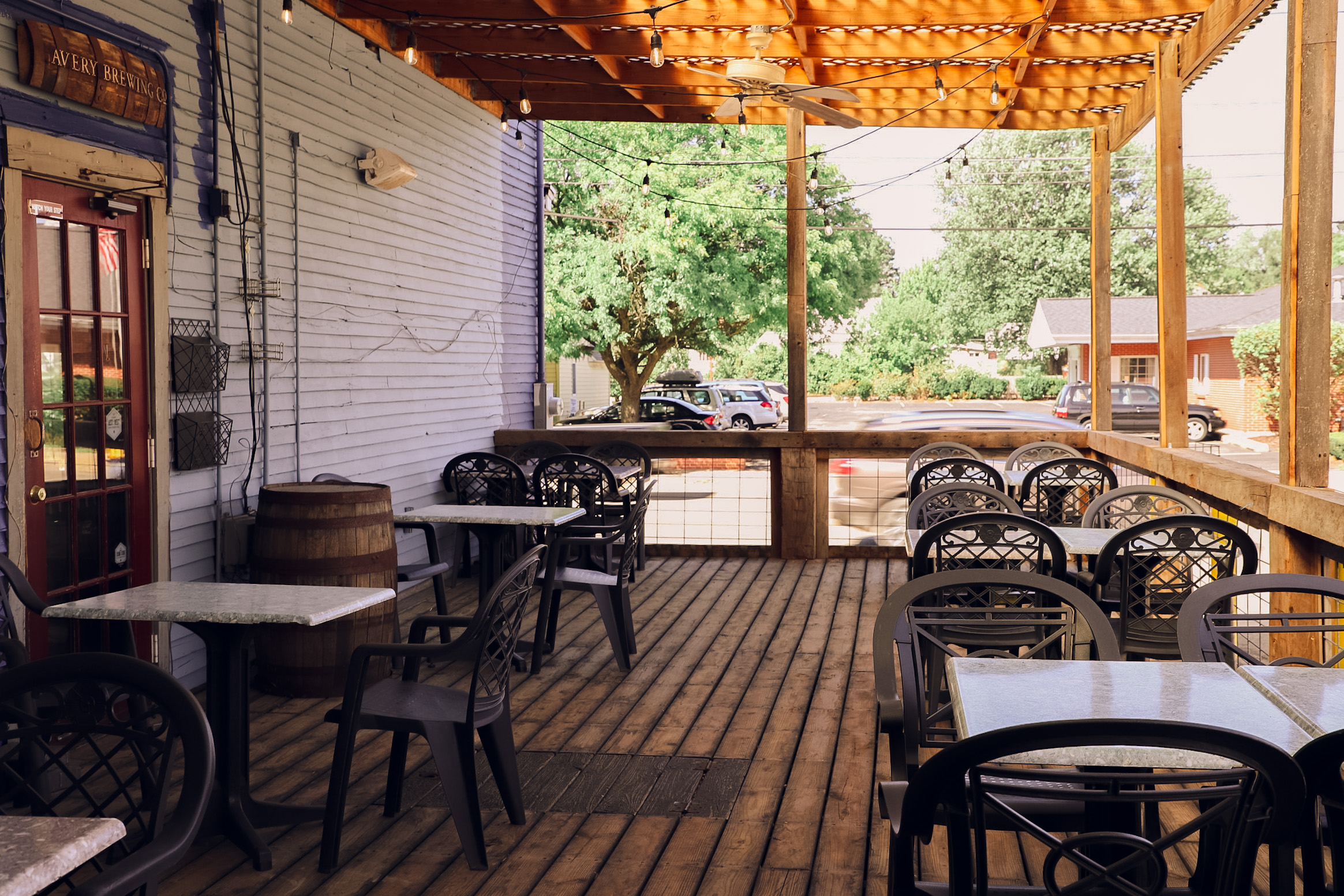 Logan's Alley patio with string lights and wood deck on a summer afternoon
